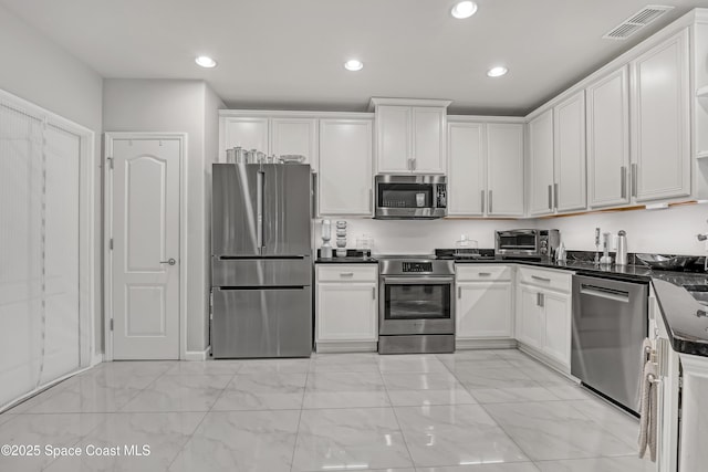 kitchen featuring dark countertops, visible vents, recessed lighting, white cabinets, and stainless steel appliances