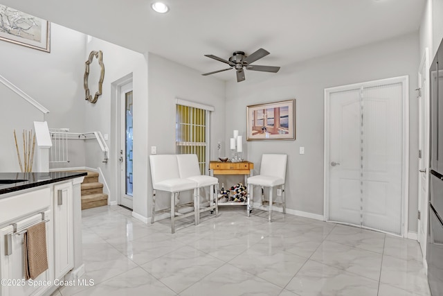 unfurnished dining area featuring recessed lighting, marble finish floor, a ceiling fan, and baseboards