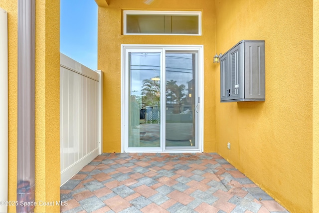 doorway to property featuring stucco siding and a patio