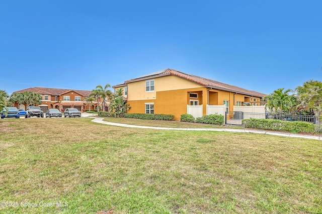 view of home's exterior with fence, a tiled roof, central AC unit, stucco siding, and a yard