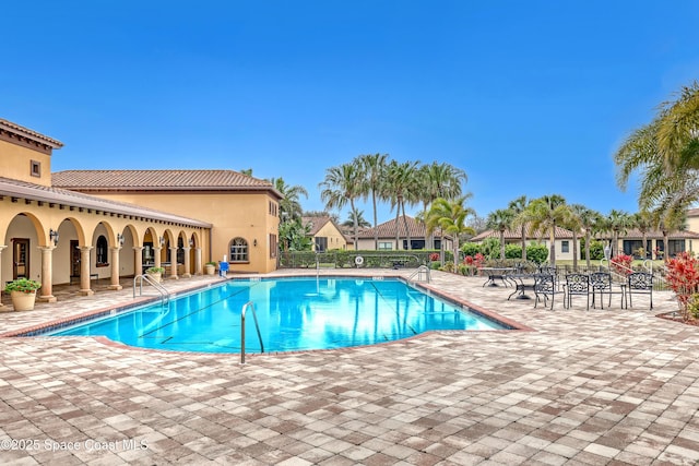 pool with a patio area and fence