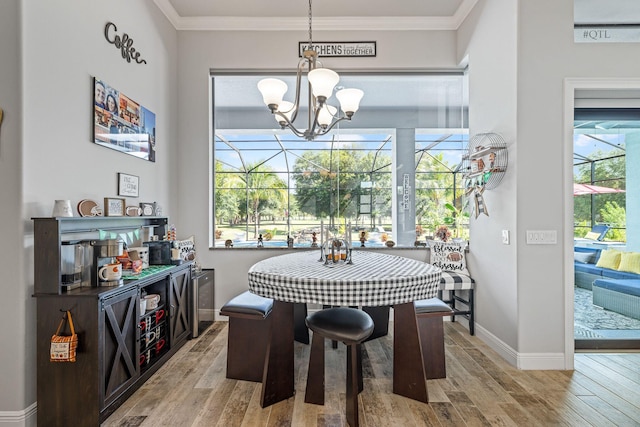 dining space featuring crown molding, light hardwood / wood-style flooring, and a chandelier