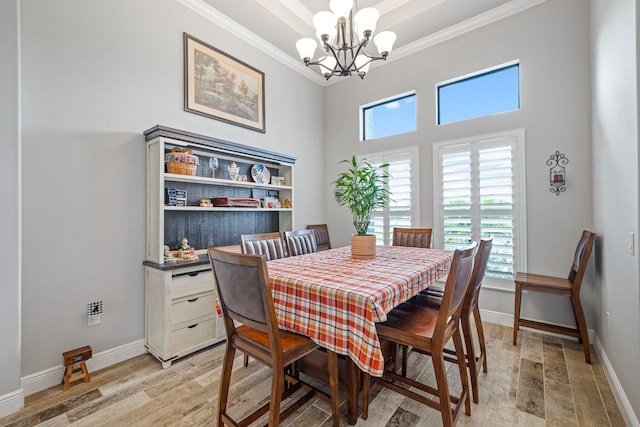 dining area with ornamental molding, a chandelier, and light wood-type flooring