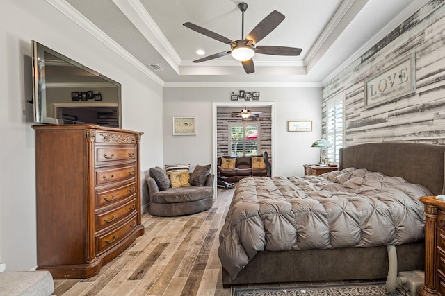 bedroom with crown molding, ceiling fan, a tray ceiling, and hardwood / wood-style floors