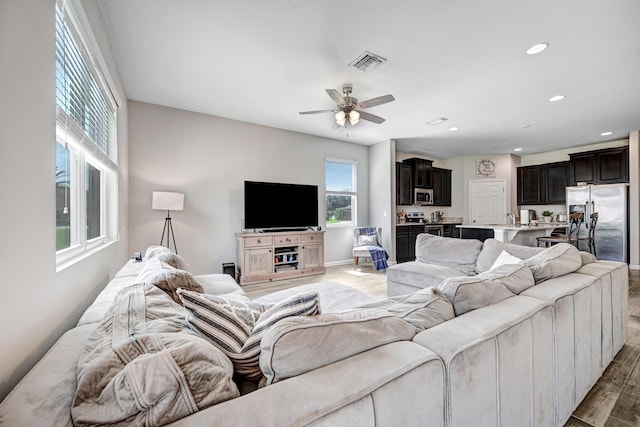 living room featuring ceiling fan and dark hardwood / wood-style flooring