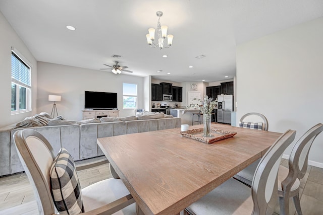 dining area with ceiling fan with notable chandelier