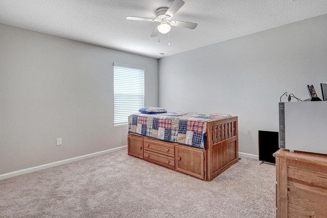 carpeted bedroom with ceiling fan and a textured ceiling