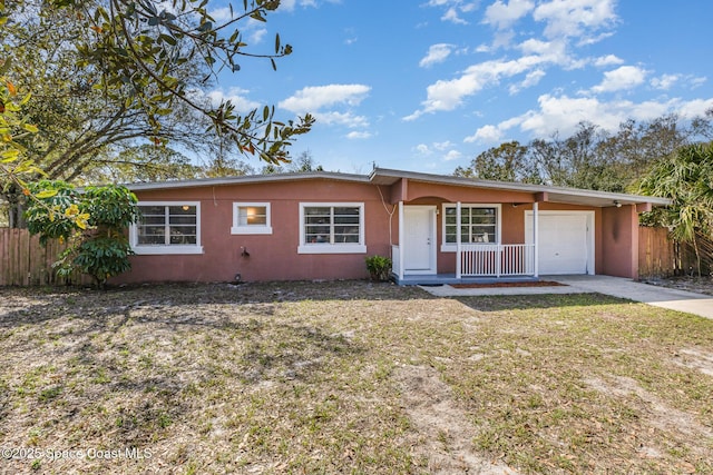 ranch-style home with a garage, a front yard, and a porch