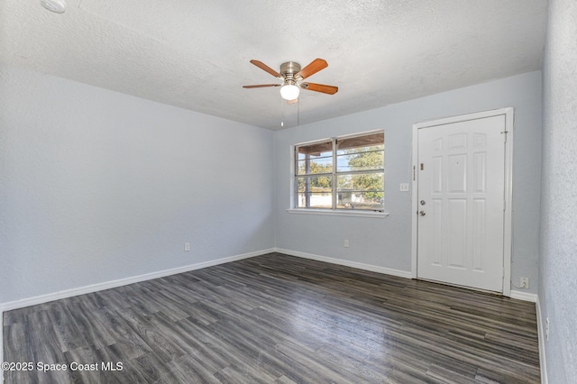 spare room with a textured ceiling, dark wood-type flooring, and ceiling fan