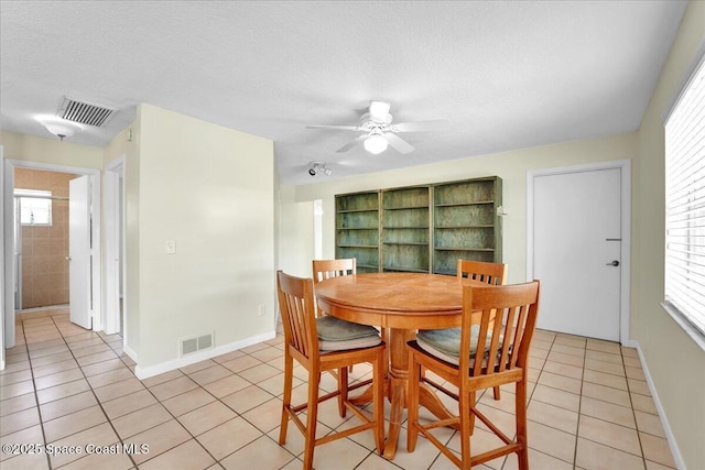 dining space featuring light tile patterned floors, a textured ceiling, and ceiling fan