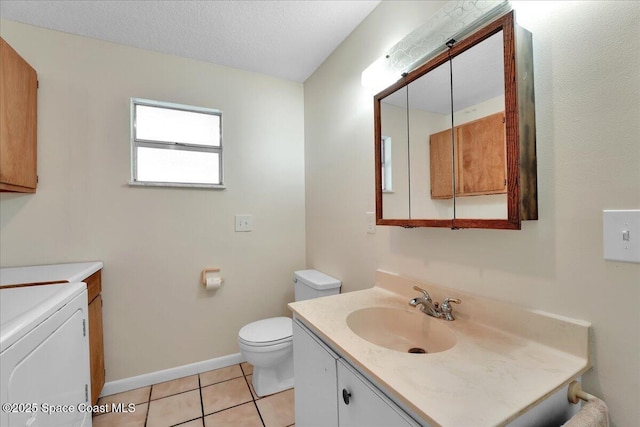 bathroom with washer / dryer, vanity, toilet, tile patterned floors, and a textured ceiling