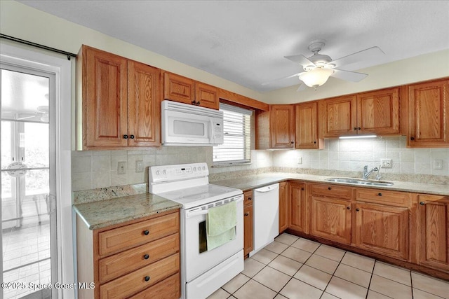 kitchen featuring sink, light tile patterned floors, white appliances, and decorative backsplash