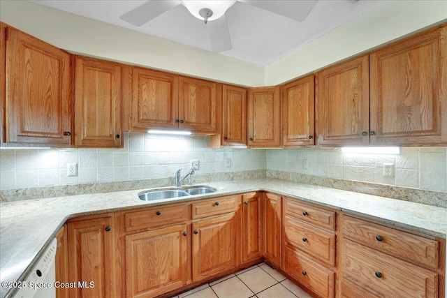 kitchen with tasteful backsplash, sink, light stone counters, and light tile patterned flooring