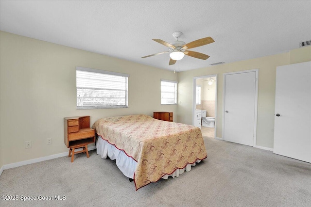 carpeted bedroom with ensuite bath, a textured ceiling, and ceiling fan