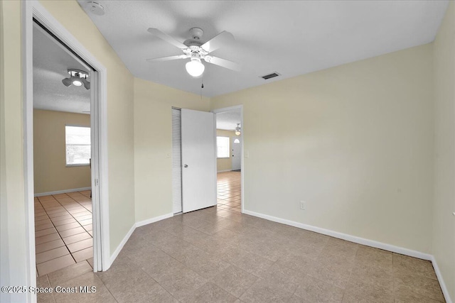 empty room with light tile patterned flooring and ceiling fan