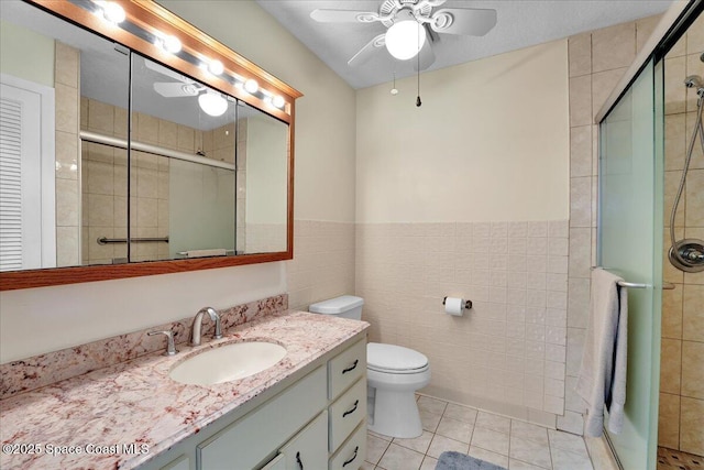 bathroom with tile patterned floors, an enclosed shower, tile walls, and vanity