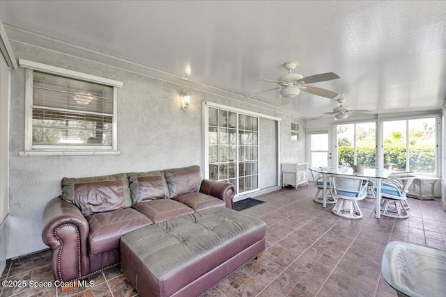 sunroom / solarium featuring ceiling fan and a healthy amount of sunlight