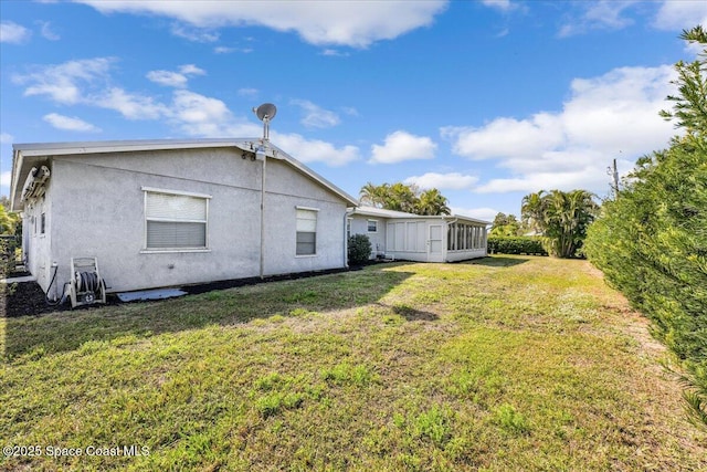 back of house with a sunroom and a yard