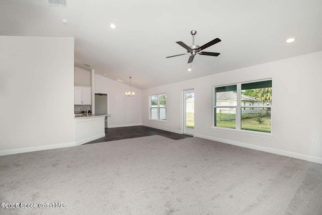 unfurnished living room with dark colored carpet, lofted ceiling, sink, and ceiling fan with notable chandelier