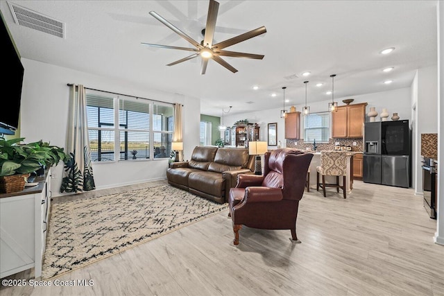 living room featuring ceiling fan and light wood-type flooring