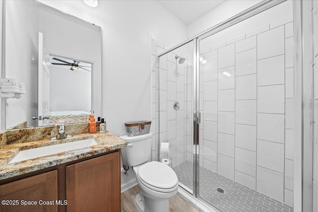 bathroom featuring hardwood / wood-style flooring, vanity, toilet, and a shower with shower door