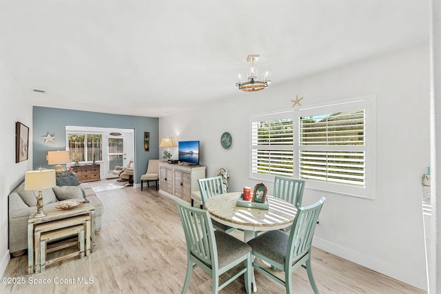 dining room featuring an inviting chandelier and light wood-type flooring