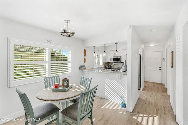 dining area featuring a notable chandelier and light hardwood / wood-style floors