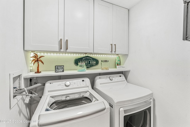 clothes washing area with cabinets and washer and dryer