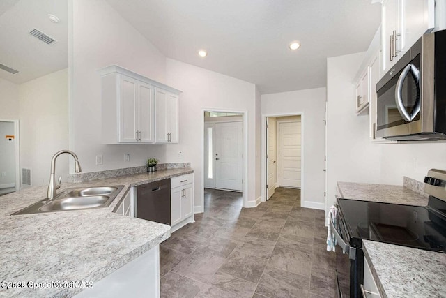 kitchen with visible vents, appliances with stainless steel finishes, light countertops, white cabinetry, and a sink