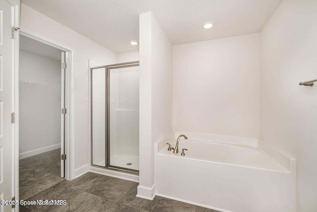 bathroom featuring a garden tub, recessed lighting, baseboards, a spacious closet, and a shower stall