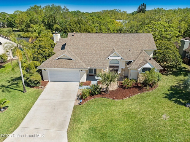 single story home featuring concrete driveway, a front yard, a garage, and roof with shingles