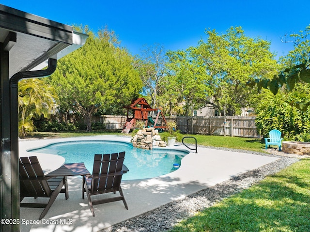 view of pool featuring a fenced in pool, a playground, a lawn, a fenced backyard, and a patio area