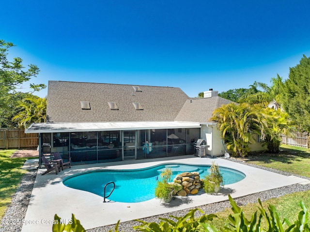 view of pool with fence, a fenced in pool, a sunroom, grilling area, and a patio area