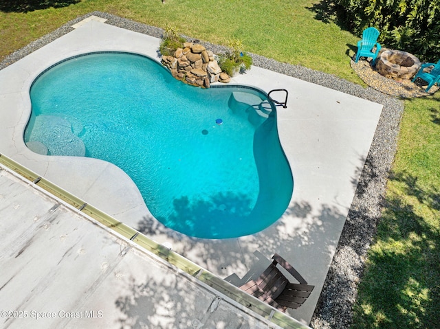 outdoor pool with a lawn, an outdoor fire pit, and a patio