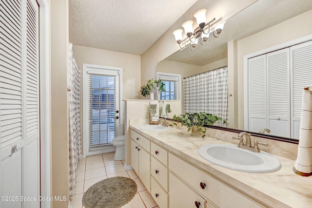 full bath with tile patterned floors, a closet, and a sink