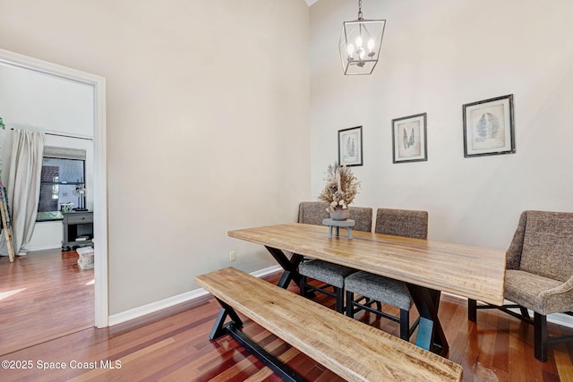 dining area featuring baseboards, an inviting chandelier, and wood finished floors