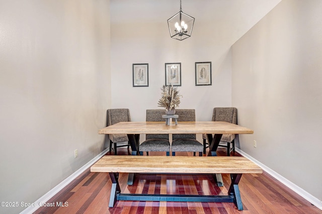 dining area featuring a notable chandelier, wood finished floors, and baseboards