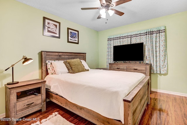 bedroom with ceiling fan, baseboards, and wood finished floors