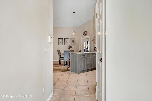 hall featuring light tile patterned floors and baseboards