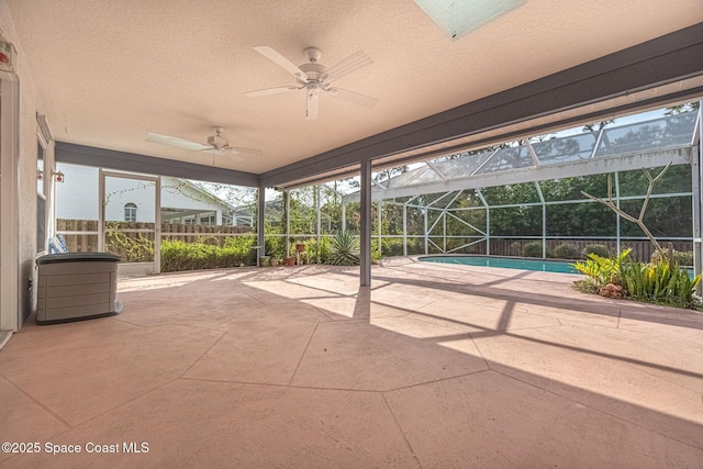 view of patio with ceiling fan and glass enclosure