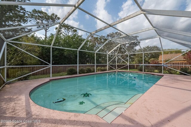 view of pool with glass enclosure and a patio area