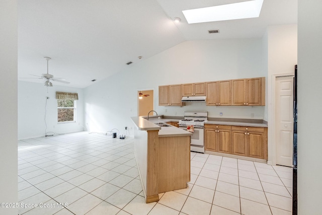 kitchen featuring sink, a skylight, light tile patterned floors, white gas range, and ceiling fan