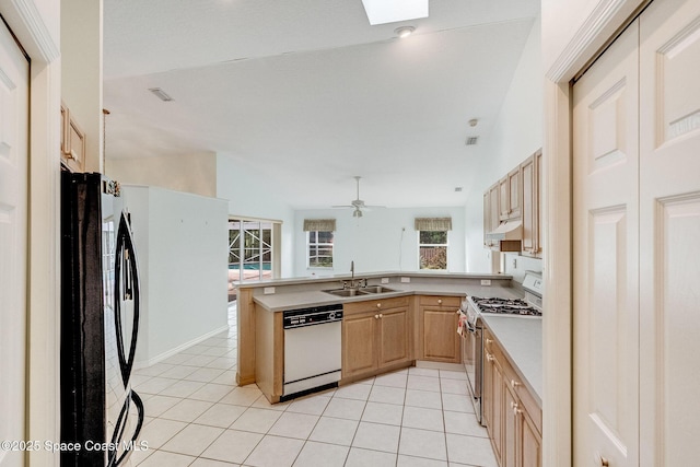 kitchen featuring black refrigerator, dishwasher, sink, gas stove, and light brown cabinets