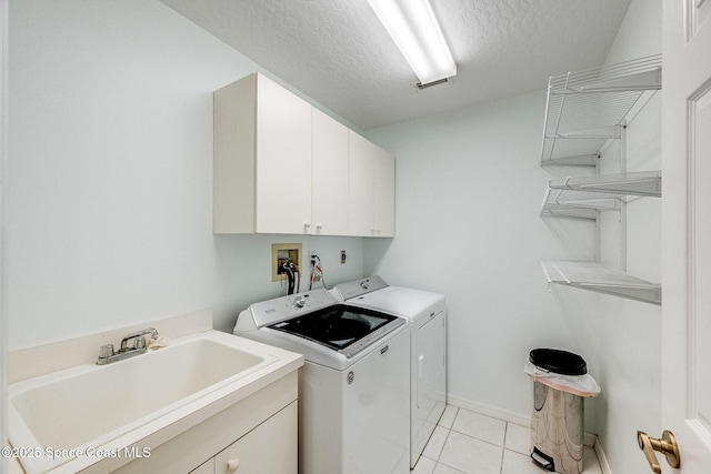 washroom featuring sink, cabinets, a textured ceiling, light tile patterned floors, and independent washer and dryer