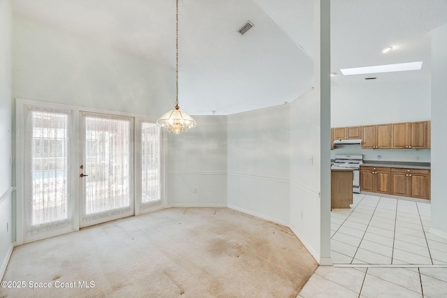 unfurnished dining area featuring a chandelier, light tile patterned floors, high vaulted ceiling, and a skylight