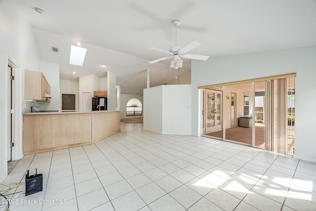 interior space with a healthy amount of sunlight, light tile patterned floors, ceiling fan, and a skylight