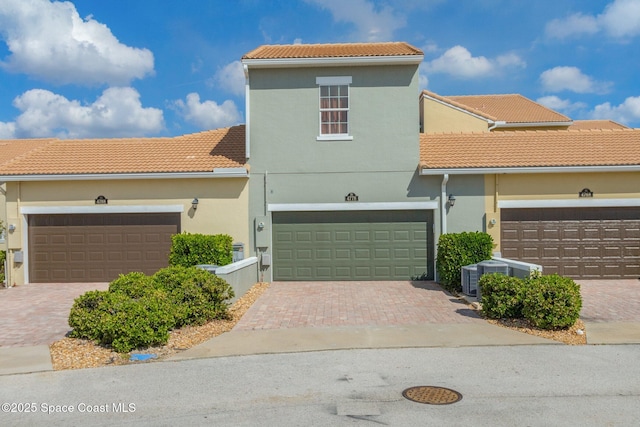 mediterranean / spanish house with a garage and central AC