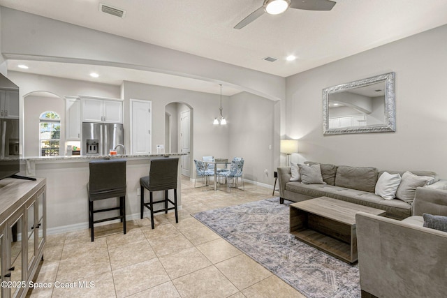 living room featuring light tile patterned floors and ceiling fan