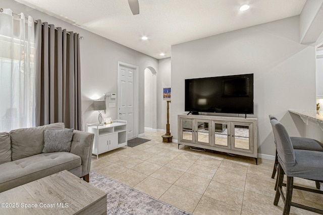 living room featuring light tile patterned floors and ceiling fan