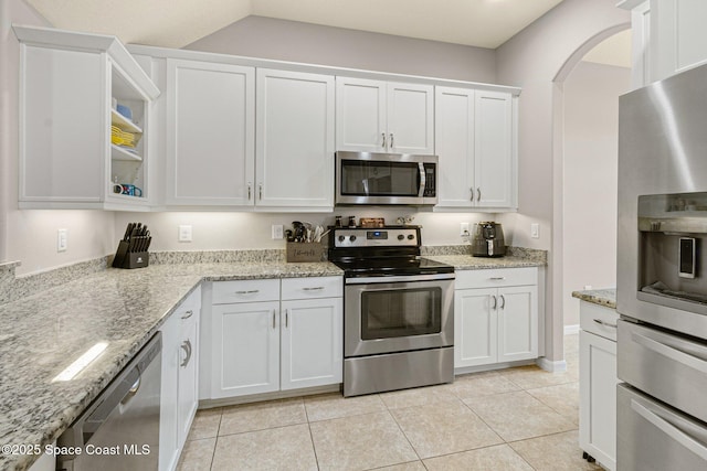 kitchen with white cabinetry, light stone counters, light tile patterned flooring, and appliances with stainless steel finishes